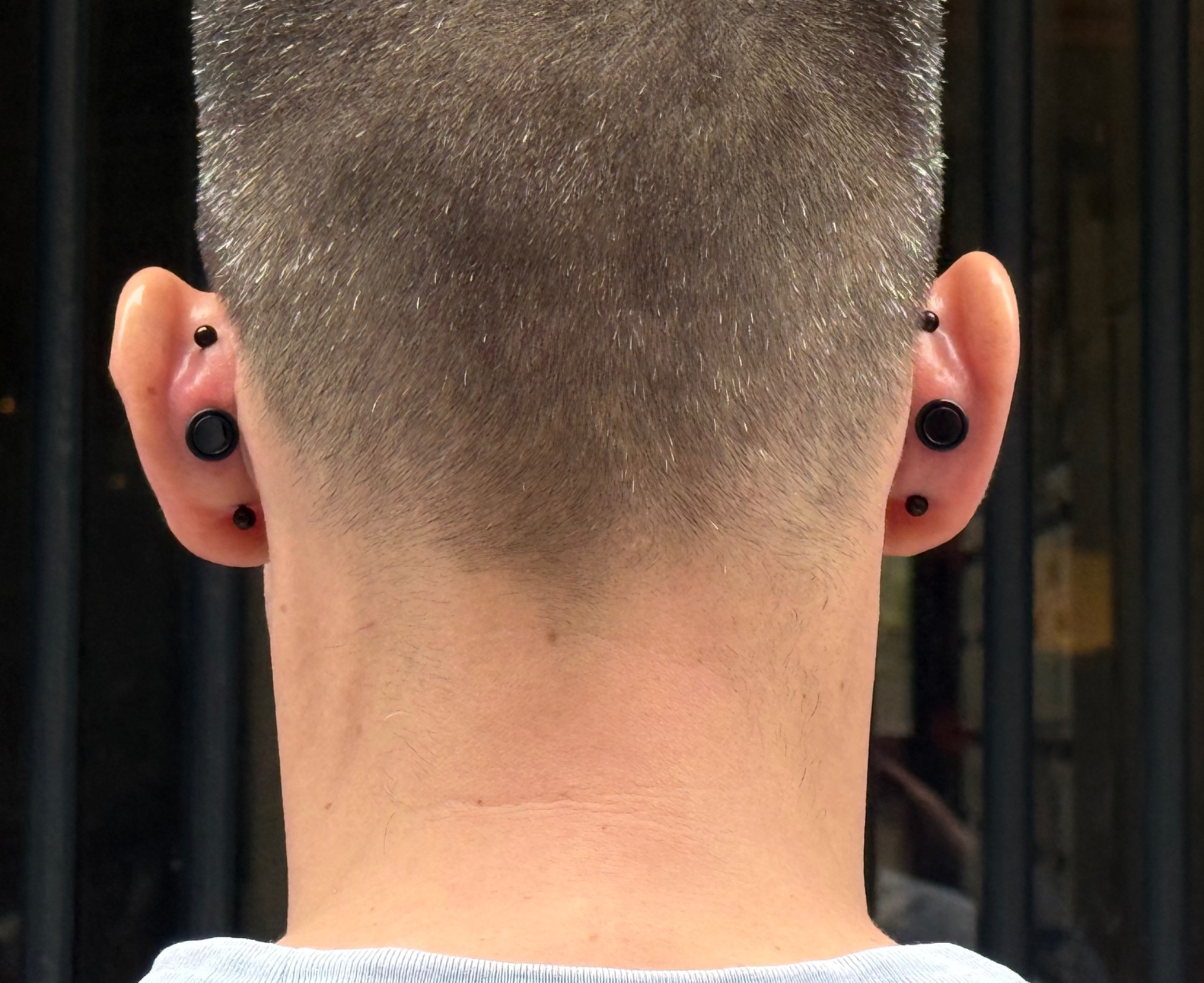 Vue arrière des deux oreilles avec piercings noirs